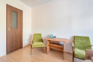 Pokój z 2 krzesłami, stołem i drzwiami w obiekcie Dom Gościnny Ewa w Rewalu