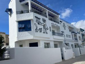 a white building with a man and a dog painted on it at Misk Villa - Boutique Hotel & Spa in Sidi Bou Saïd