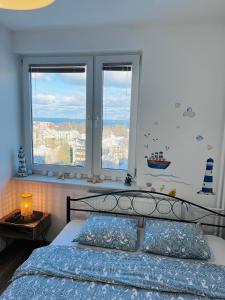 um quarto com uma cama e duas janelas em Apartament Karlikowska z widokiem na morze em Sopot