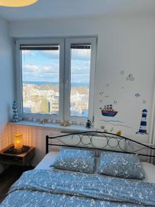 sypialnia z łóżkiem i dwoma oknami w obiekcie Apartament Karlikowska z widokiem na morze w mieście Sopot