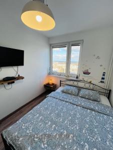 1 dormitorio con 1 cama y TV de pantalla plana en Apartament Karlikowska z widokiem na morze en Sopot