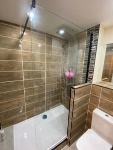 a bathroom with a shower and a toilet at Urban Oasis: North London in Edmonton