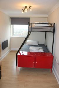 a red bunk bed in a room with a window at Urban Oasis: North London in Edmonton