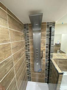 a shower in a bathroom with brown tiles at Urban Oasis: North London in Edmonton