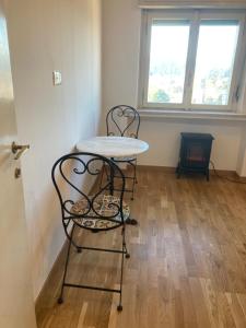 un tavolo e due sedie in una stanza con finestra di Attico Verdi a Gorizia