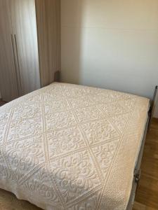 una camera da letto con un letto con copriletto bianco di Attico Verdi a Gorizia
