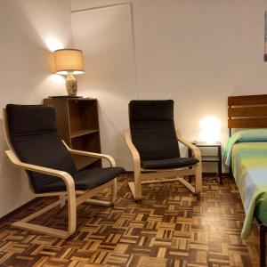 two chairs and a bed in a room at Sweet Home in Torino Cenisia in Turin