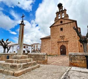 an old brick church with a cross on top of it at Casa Rural Verde Oliva in Baños de la Encina