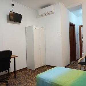 a bedroom with a bed and a desk and a tv at Sweet Home in Torino Cenisia in Turin