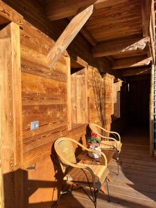 2 sillas y una mesa en el porche de una cabaña en CASA VITTORIA, en Gignod