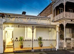 a white house with a fence and potted plants at Melbourne Fitzroy Terrace in Melbourne