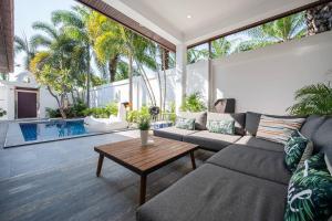 パタヤ・サウスにあるMajestic Residence Pool Villas 2 Bedrooms Private Beachのリビングルーム(ソファ、テーブル付)