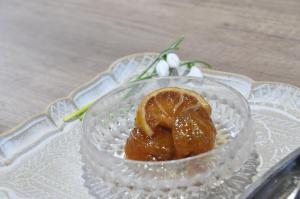a glass bowl with a peeled orange on a glass plate at Domaćinstvo Ukusno Marković in Brusnik