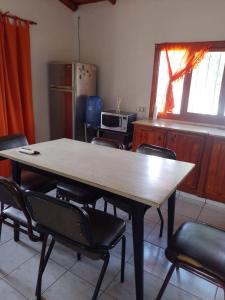 a table and chairs in a room with a kitchen at Cabañas "Las Acacias" in Villa Santa Cruz del Lago