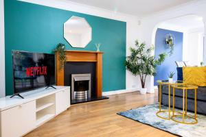 a living room with a tv and a fireplace at *3Bed House Central location Free Parking Perfect for contractors & groups Managed by Chique Properties Ltd in Great Linford
