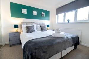 1 dormitorio con 1 cama grande y 2 ventanas en *3Bed House Central location Free Parking Perfect for contractors & groups Managed by Chique Properties Ltd, en Great Linford