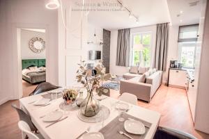 a dining room and living room with a table and chairs at Family Luxury Wonder Heaven Apartment, 50m to M Cassino, first with 3 badrooms&studio, second with 2 badrooms&studio, parking w cenie in Sopot