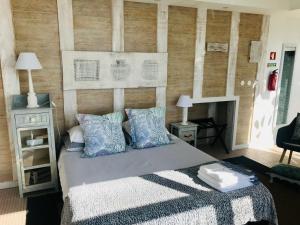 a bedroom with a bed with blue pillows and a fireplace at A Villa by the Sea Bed & Breakfast in Vila Franca do Campo