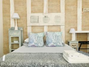 a bedroom with a bed with pillows and a wooden wall at A Villa by the Sea Bed & Breakfast in Vila Franca do Campo