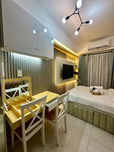 1 dormitorio con 1 cama, mesa y sillas en City Nest Makati with Rooftop pool and Free Netflix en Manila