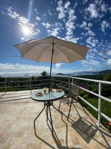 - une table avec un parasol sur la terrasse dans l'établissement Recanto Filadélfia, à Parati
