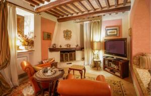 een woonkamer met een bank en een televisie bij 3 Bedroom Stunning Apartment In Rapolano Terme in Rapolano Terme
