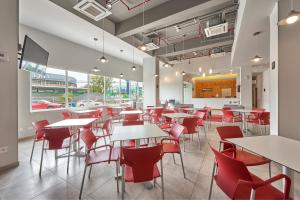 une salle à manger avec des tables et des chaises rouges dans l'établissement City Express Junior by Marriott Mexicali, à Mexicali