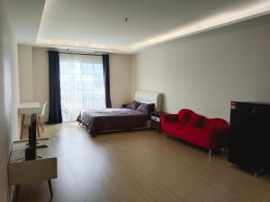 1 dormitorio con 1 cama y 1 sofá rojo en Swimming pool view en Kampar