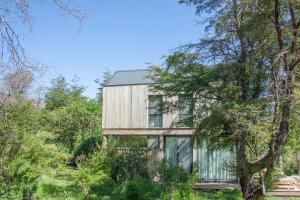 una casa de madera en medio de un bosque en Calma Sur Hoteleria Boutique en Villa Meliquina