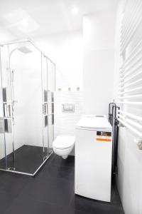 biała łazienka z toaletą i prysznicem w obiekcie Lovely studio close to the Center. Free Parking w Warszawie