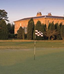 a golf course with a checkered flag in front of a building at Macdonald Linden Hall Hotel, Golf & Spa in Longhorsley