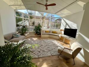 a living room with a ceiling fan and a large window at Bord de mer, magnifique appartement de 150m2 avec jardin in Marseille