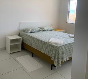 um quarto com uma cama com uma colcha verde em VIRASSOL Praia Hotel em Salvador