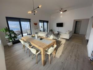 a dining room and living room with a table and chairs at Sunset Hills Transylvania in Odorheiu Secuiesc