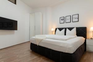 a bedroom with a large bed with white sheets at Bodensee Loft - 116 m² Traumwohnung in Uhldingen-Mühlhofen