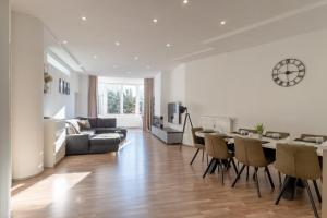 a living room with a couch and a table and chairs at Bodensee Loft - 116 m² Traumwohnung in Uhldingen-Mühlhofen