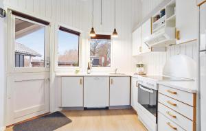 a kitchen with white cabinets and a window at Holiday Home Solbjergvej Sydals Denm in Høruphav +13 photos