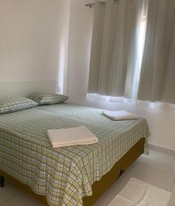 um quarto com uma cama com duas toalhas em VIRASSOL Praia Hotel em Salvador