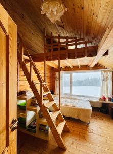 a bunk bed in a wooden room with a staircase at Kam In in Krivopolʼye