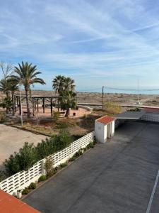 ein Parkplatz mit einem weißen Zaun und Palmen in der Unterkunft Almenara Beach in Almenara