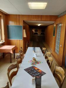 een klaslokaal met een tafel en stoelen en een schoolbord bij Hotel Lava Vulkaneifel in Daun