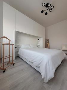 Habitación blanca con cama grande y lámpara de araña. en FRANZHOUSE, en Ponte San Pietro