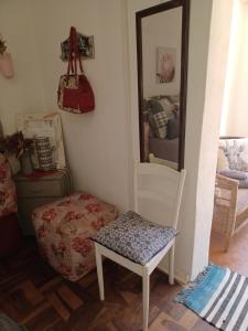 Shalom guesthouse في بلومفونتين: غرفة بها كرسي ومرآة