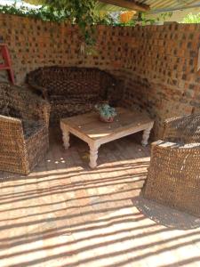 Shalom guesthouse في بلومفونتين: فناء مع طاولة و كرسيين الخوص