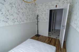 a small room with a bed and a hallway at South House in Włocławek