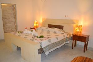 a bedroom with a bed with a table and two lights at Aquarius Club in Watamu