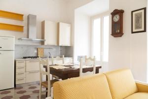 a kitchen with a table with chairs and a clock on the wall at Anita, centro storico in Pisa