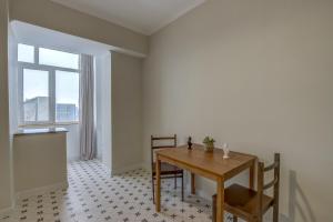 a dining room with a table and chairs and a window at Quite apartment in Bishkek