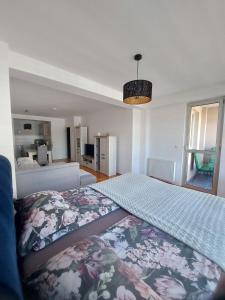 - une chambre dotée d'un grand lit avec un couvre-lit floral dans l'établissement Apartman city center 4-šetalište, à Prijedor