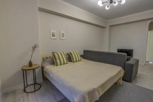 1 dormitorio con cama, sofá y mesa en Quite apartment en Bishkek